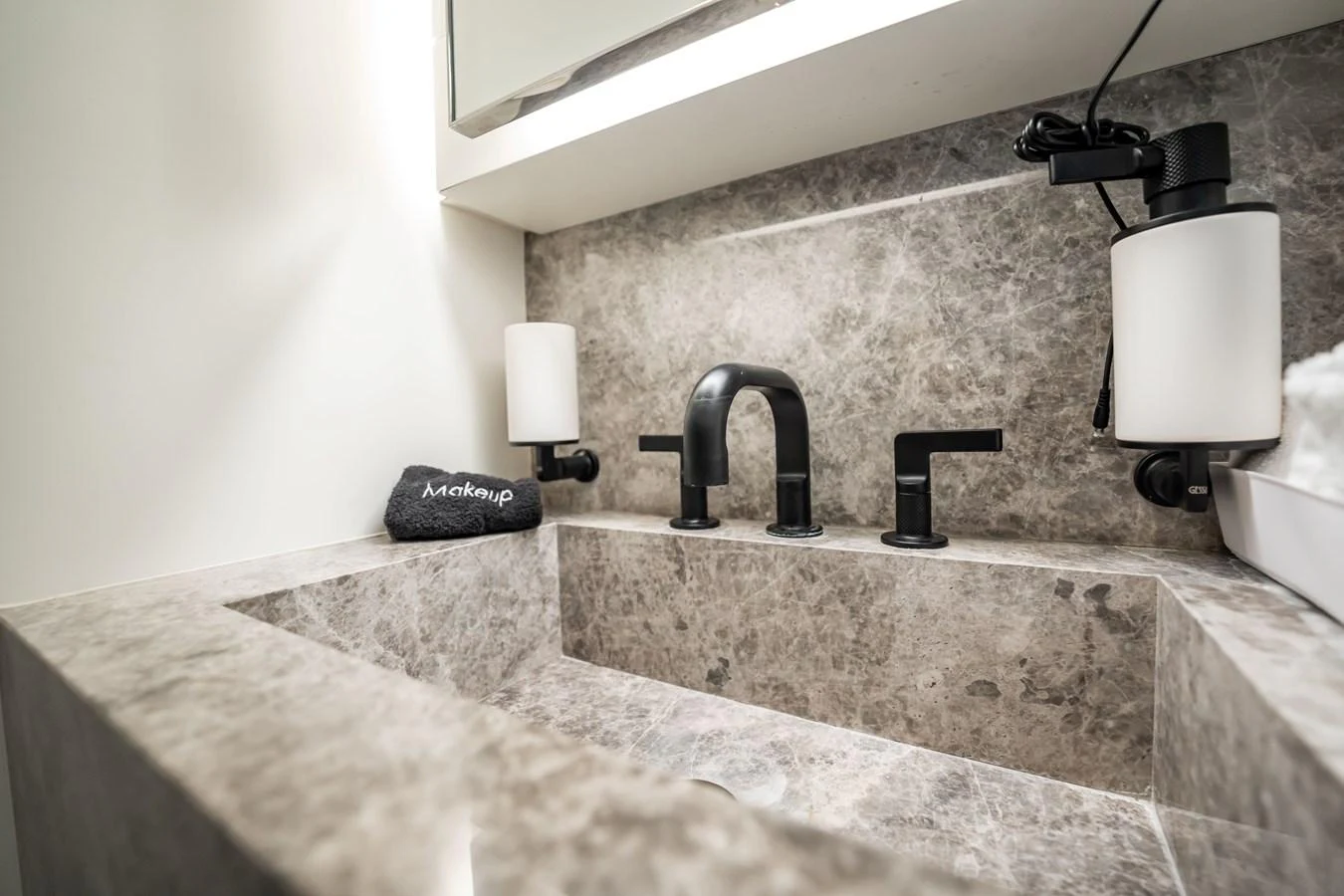 A luxurious bathroom sink area with elegant marble surfaces and modern fixtures. aboard HOTEL COLLECTION Yacht for Sale