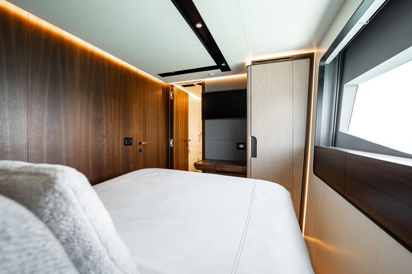 A luxurious stateroom featuring modern wood paneling and ambient lighting. aboard HOTEL COLLECTION Yacht for Sale