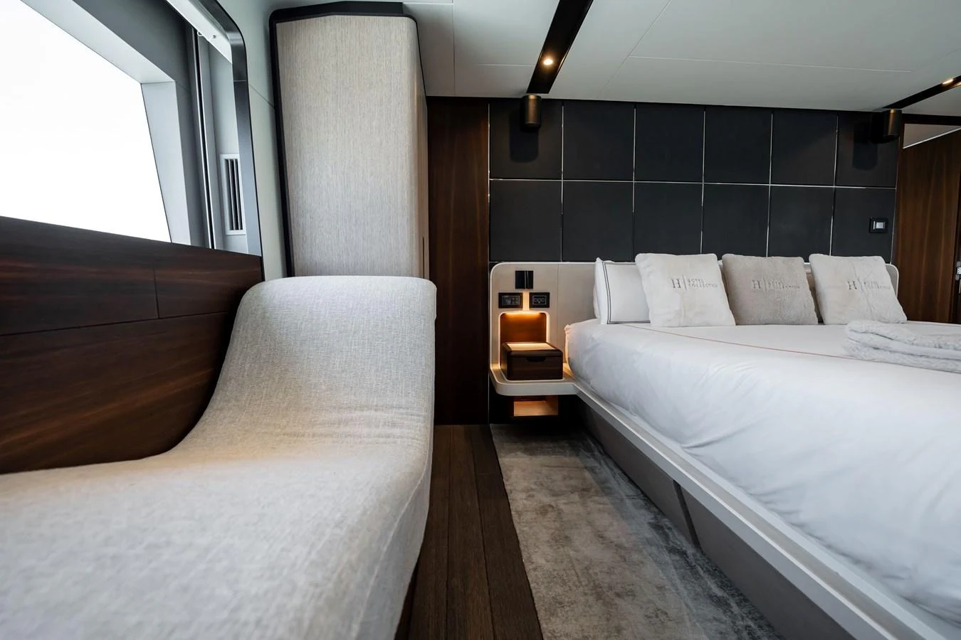 The master stateroom features a luxurious bed and a comfortable seating area with modern design elements. aboard HOTEL COLLECTION Yacht for Sale