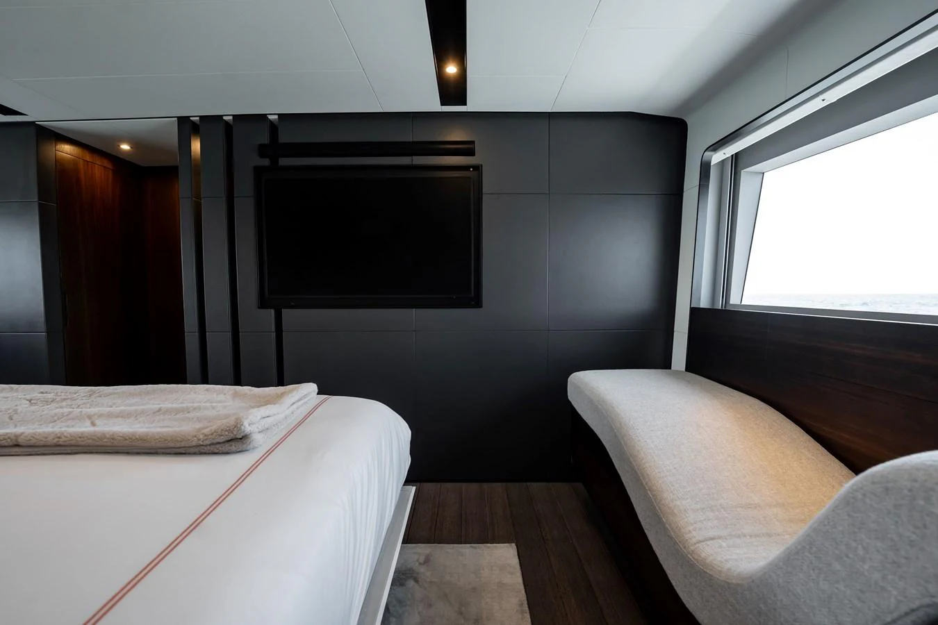 The stateroom features a modern design with a large window offering natural light and a comfortable seating area. aboard HOTEL COLLECTION Yacht for Sale