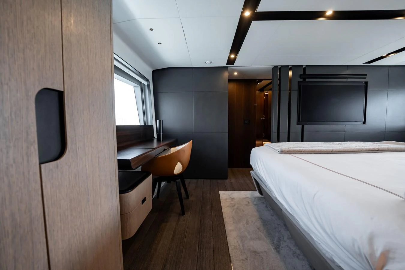 The stateroom features a sleek, modern design with a comfortable bed and a work desk by the window. aboard HOTEL COLLECTION Yacht for Sale