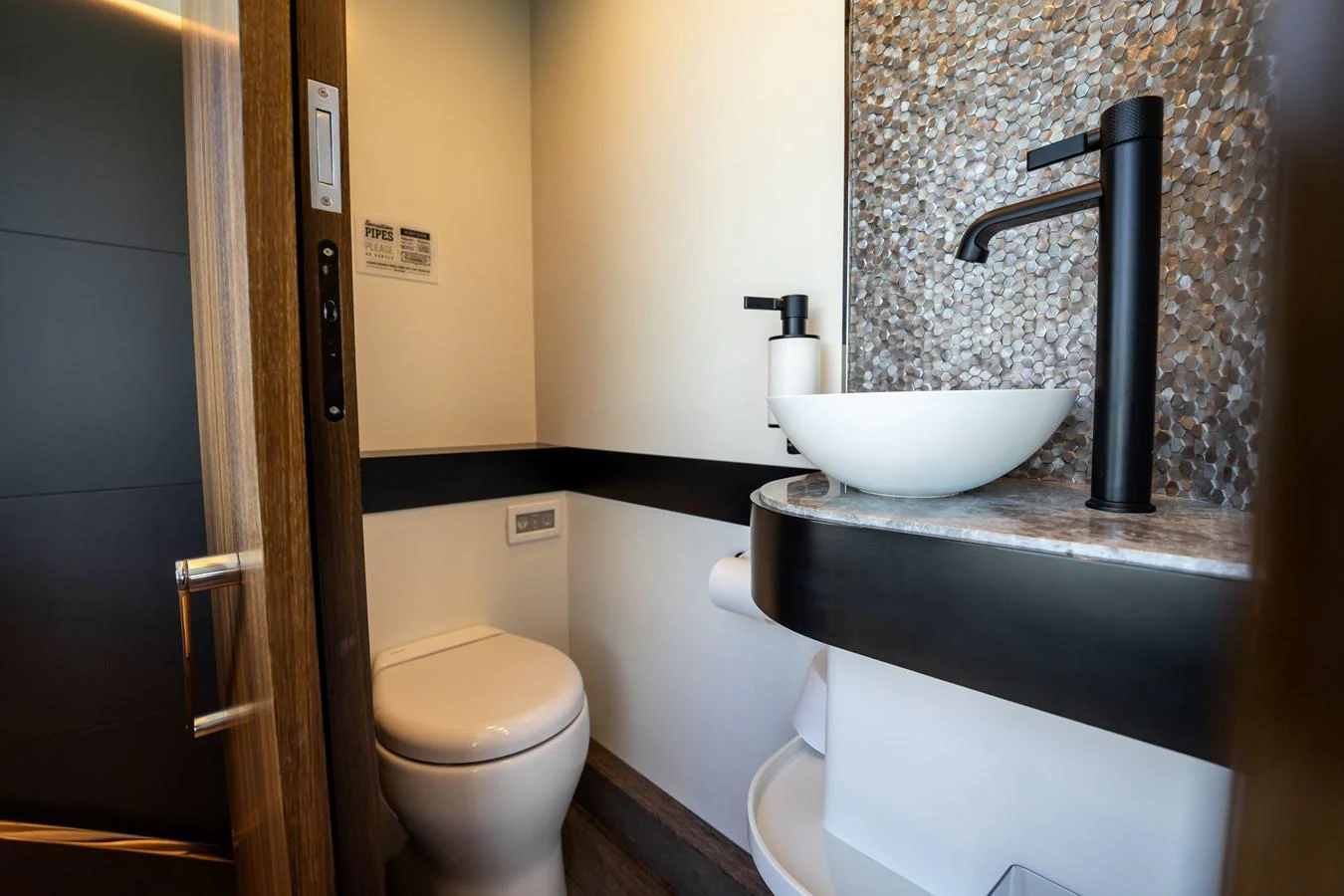 A modern yacht bathroom featuring a sleek sink and contemporary fixtures. aboard HOTEL COLLECTION Yacht for Sale