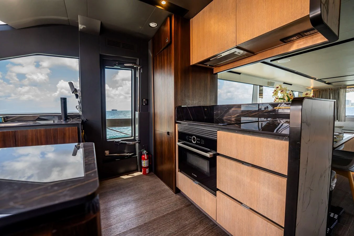 The yacht's galley features modern appliances and sleek wood cabinetry, offering a stylish and functional space for meal preparation. aboard HOTEL COLLECTION Yacht for Sale