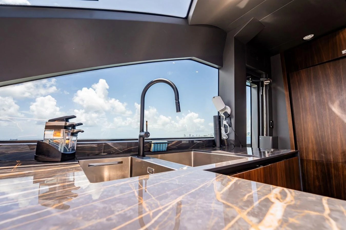 The yacht's galley features modern appliances and a sleek design with a large window offering stunning views. aboard HOTEL COLLECTION Yacht for Sale