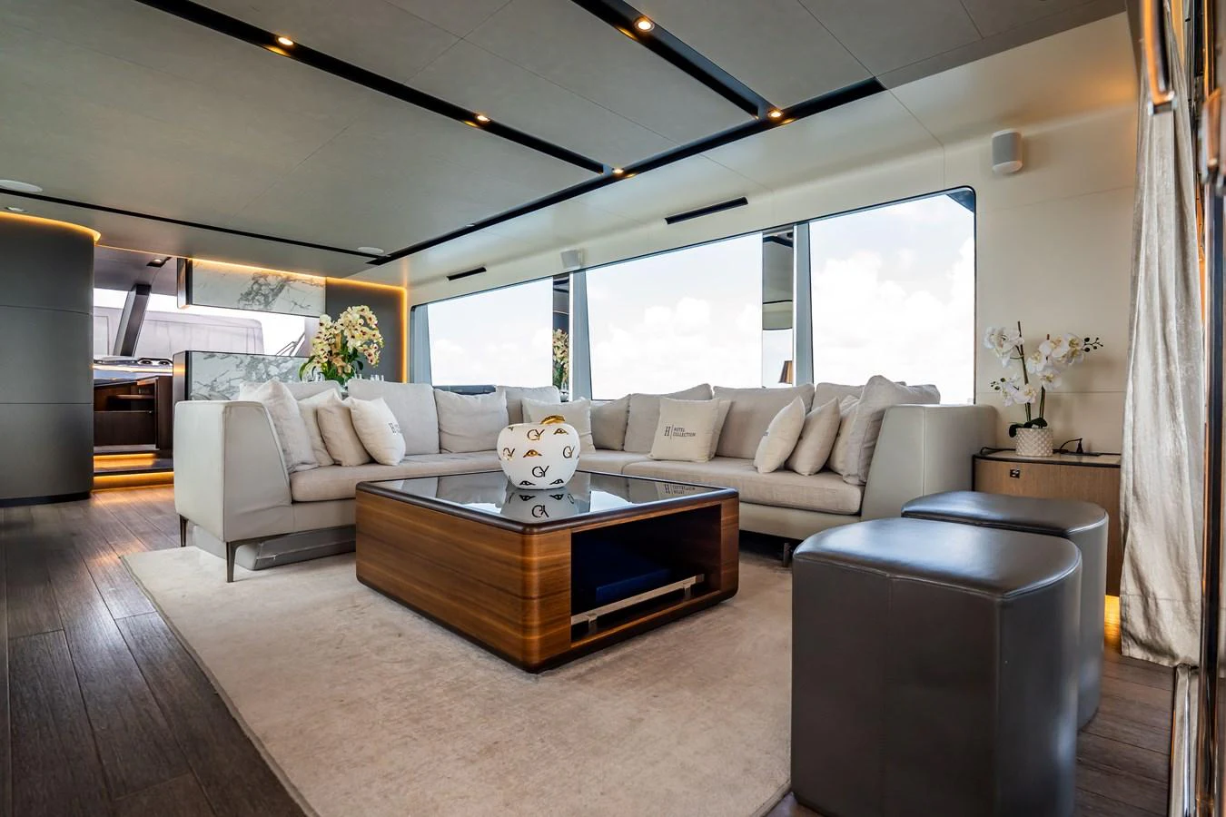 The salon features a spacious and elegant seating area with modern decor and large windows offering panoramic views. aboard HOTEL COLLECTION Yacht for Sale