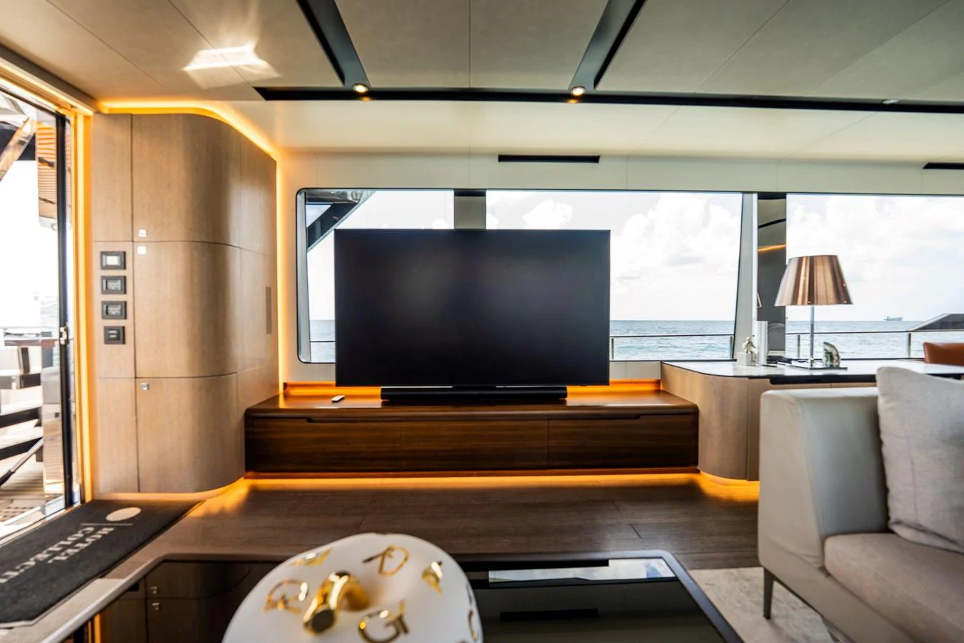 The salon features a modern entertainment system with a large flat-screen TV and elegant decor. aboard HOTEL COLLECTION Yacht for Sale