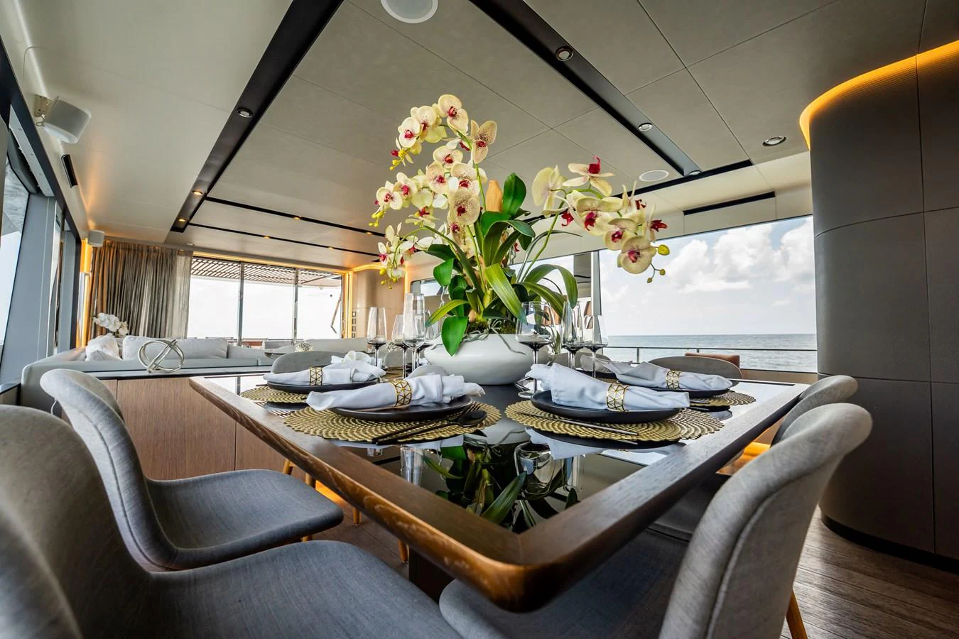 The yacht's dining area features a beautifully set table with elegant decor and a stunning view of the ocean. aboard HOTEL COLLECTION Yacht for Sale