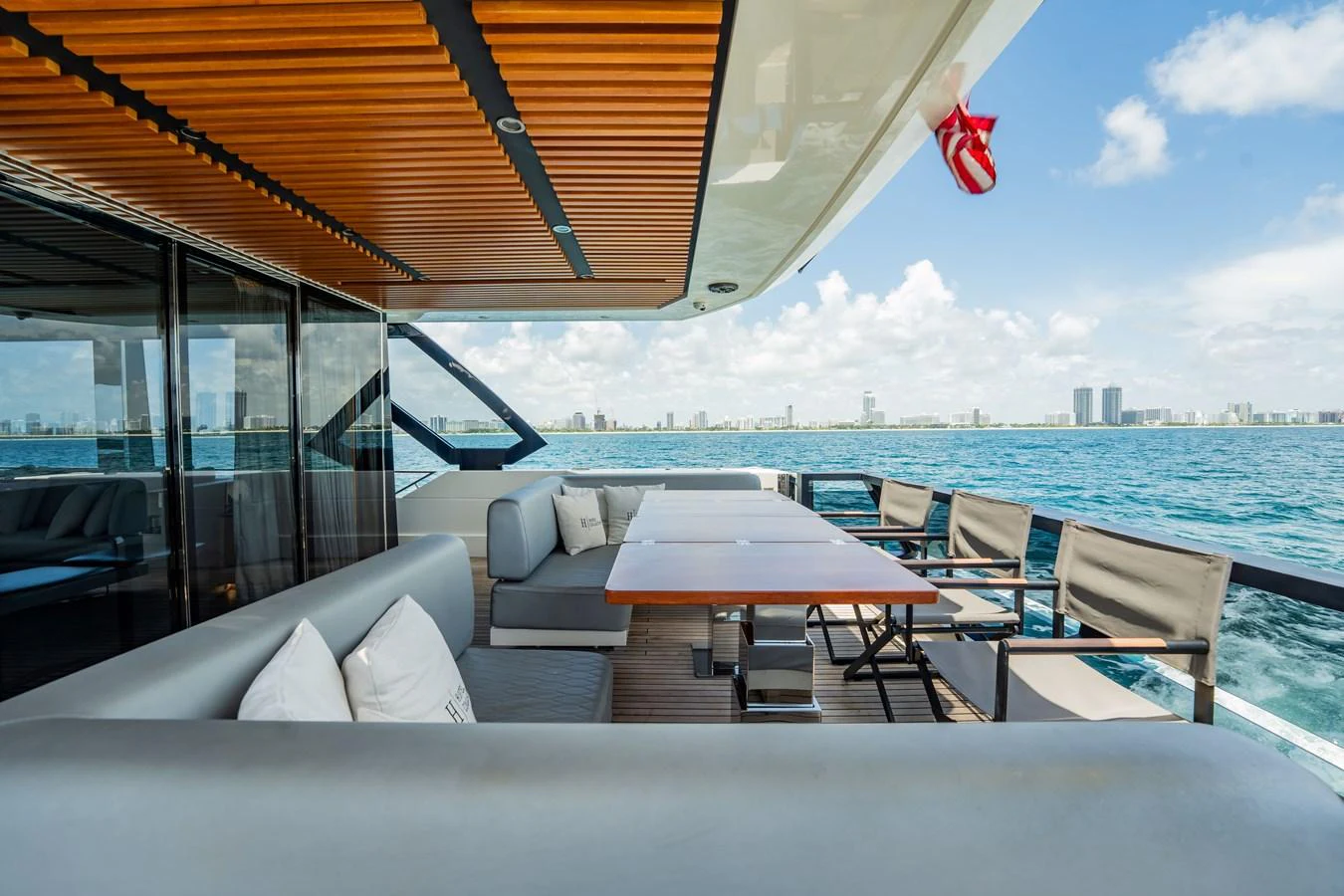 The aft deck features a spacious seating area with a dining table, perfect for enjoying meals with a view of the sea. aboard HOTEL COLLECTION Yacht for Sale