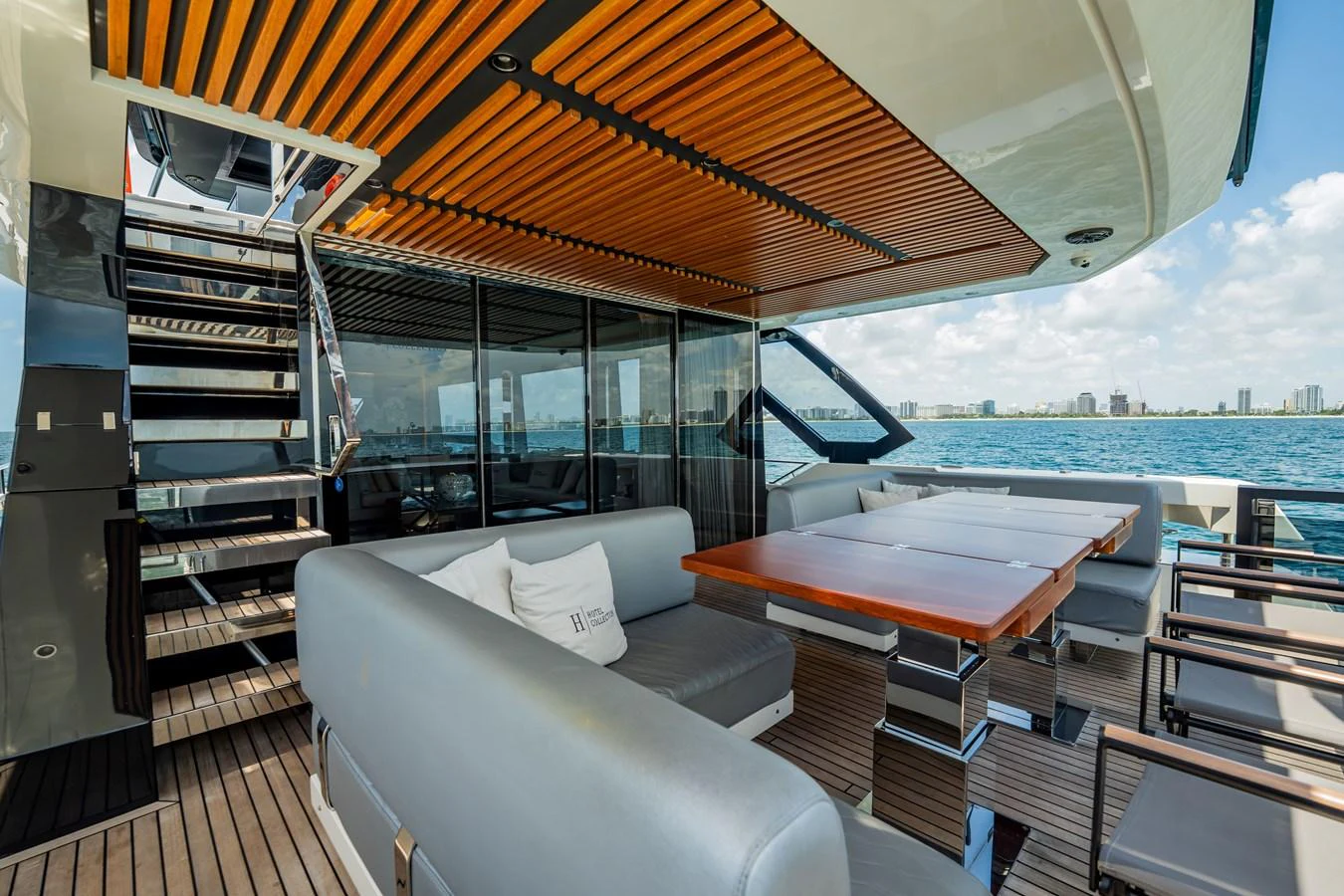 The aft deck offers a stylish and comfortable outdoor dining area with a view of the water. aboard HOTEL COLLECTION Yacht for Sale