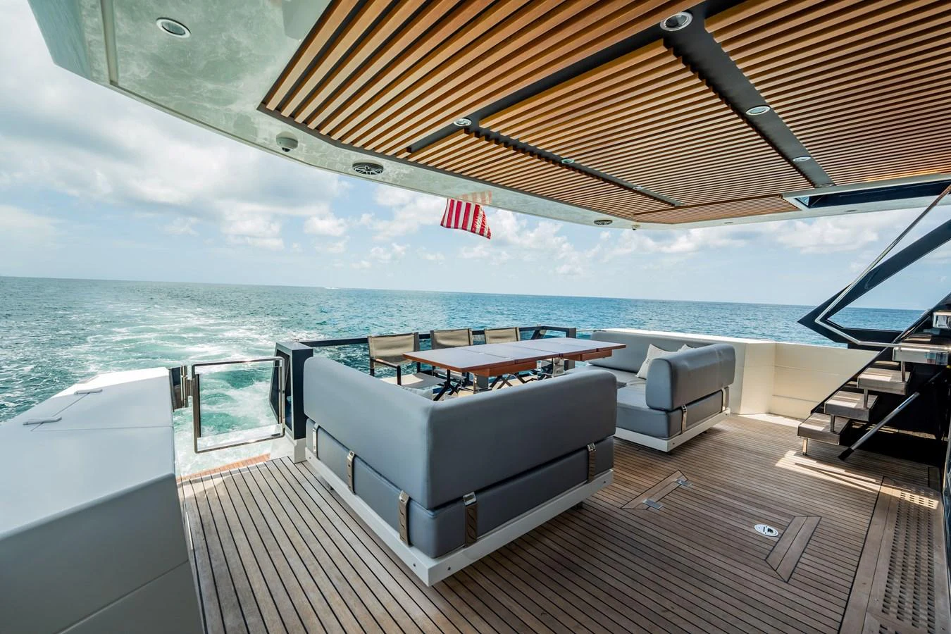 The aft deck features a spacious seating area with a dining table, offering stunning ocean views. aboard HOTEL COLLECTION Yacht for Sale