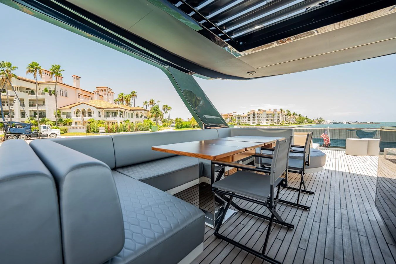 The aft deck offers a spacious and comfortable seating area with a dining table, perfect for alfresco meals and relaxation. aboard HOTEL COLLECTION Yacht for Sale