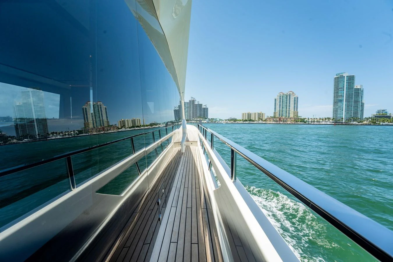A sleek yacht glides through the water with a stunning cityscape in the background. aboard HOTEL COLLECTION Yacht for Sale