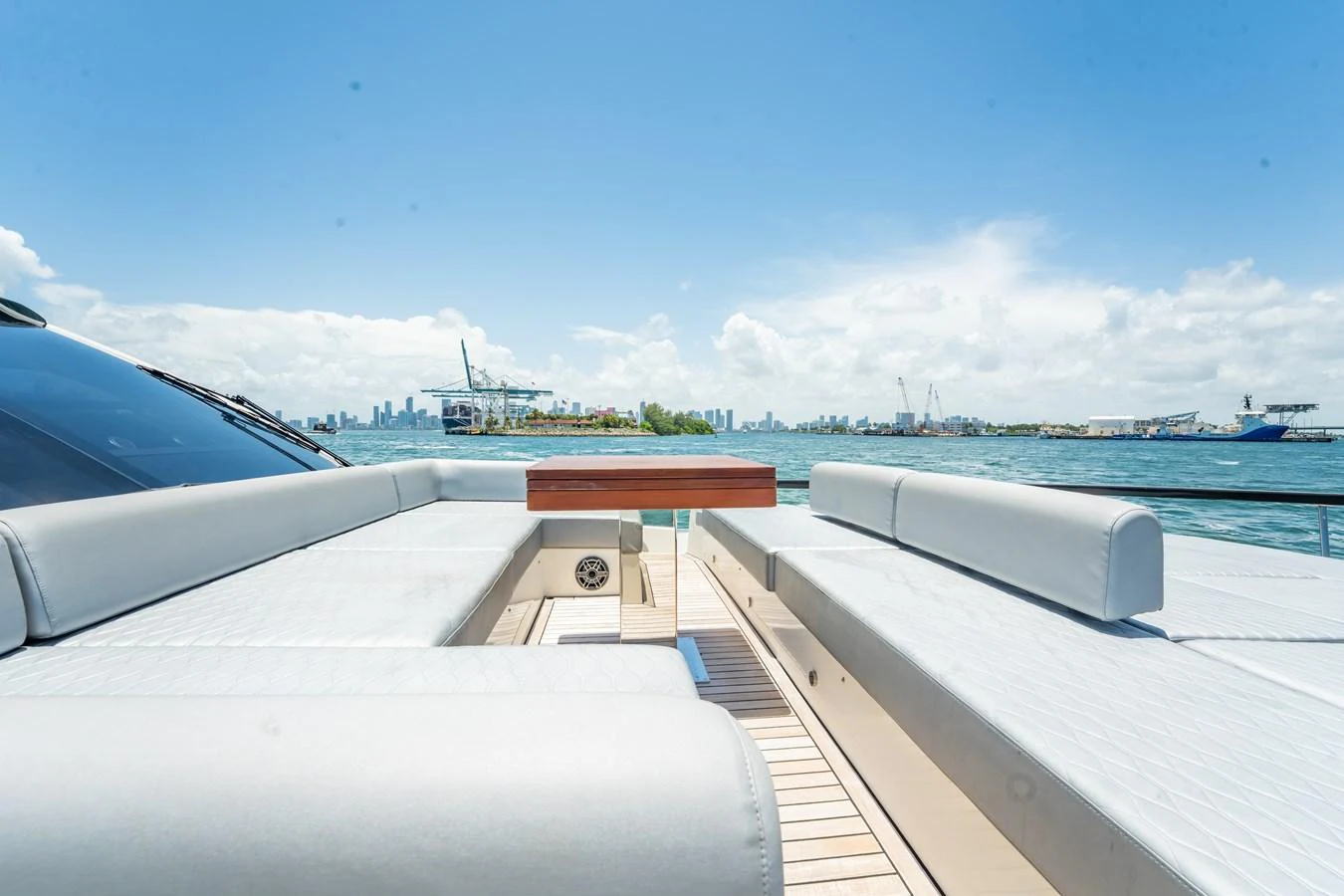 The yacht's aft deck features a spacious seating area with a stunning view of the water and skyline. aboard HOTEL COLLECTION Yacht for Sale