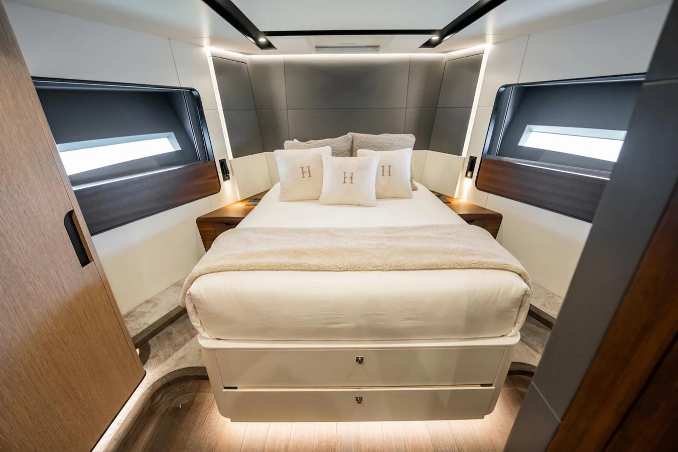 The stateroom features a luxurious bed with elegant pillows and modern lighting. aboard HOTEL COLLECTION Yacht for Sale