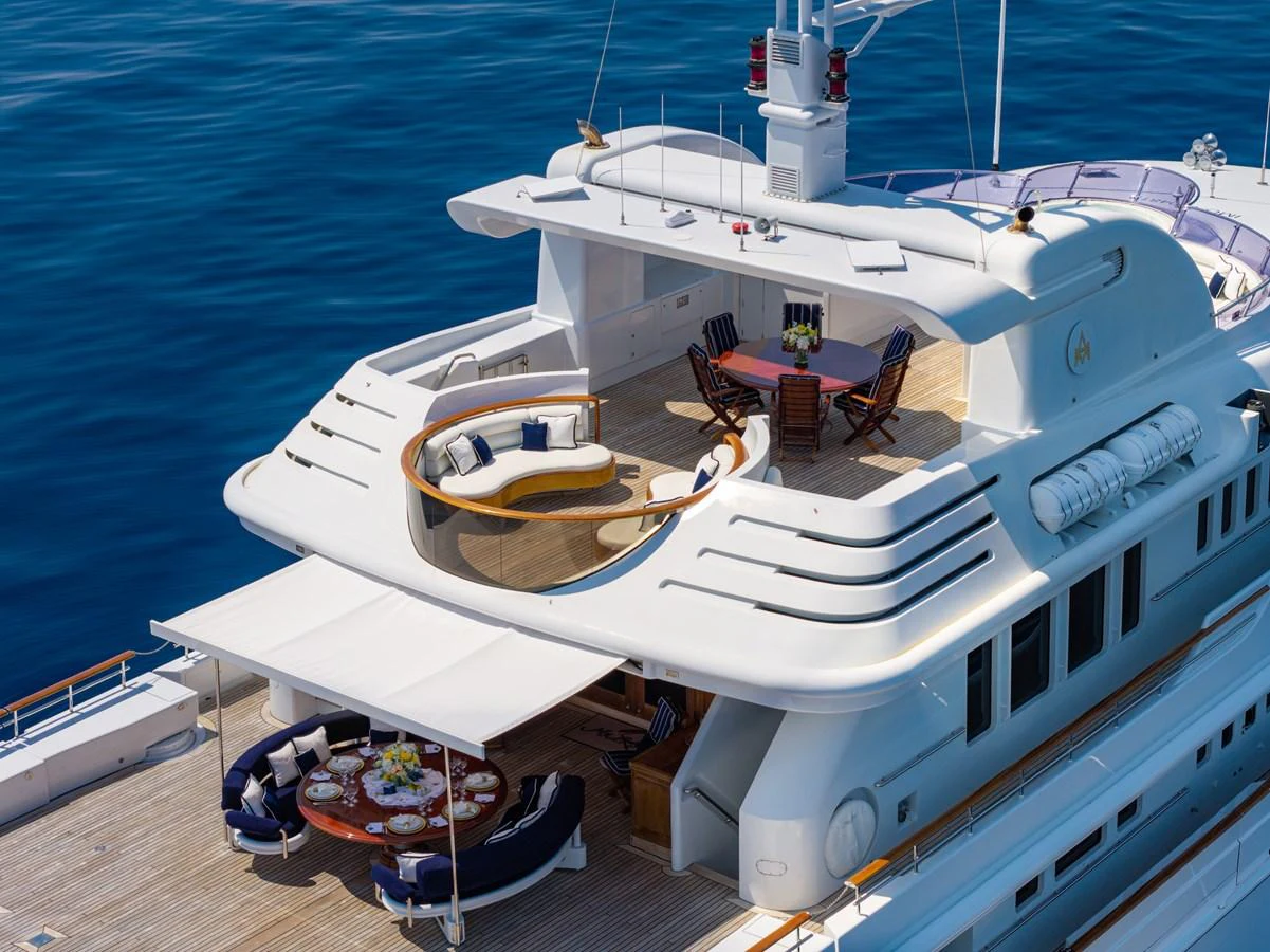 The yacht's aft deck features elegant outdoor dining and lounging areas with stunning ocean views. aboard MY LADY Yacht for Sale