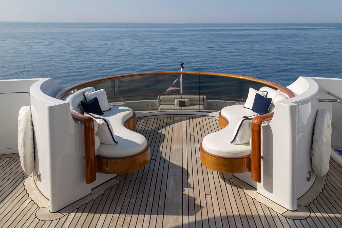 The aft deck features elegant curved seating with plush cushions, offering a serene view of the open sea. aboard MY LADY Yacht for Sale