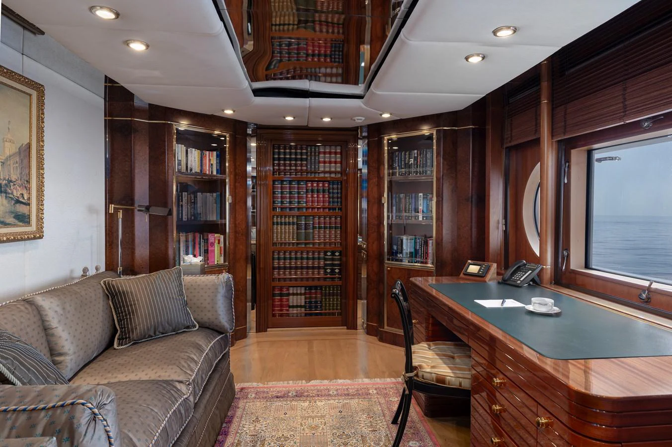 The yacht's study features elegant wood paneling, a comfortable sofa, and a well-stocked bookshelf, creating a refined and cozy atmosphere. aboard MY LADY Yacht for Sale