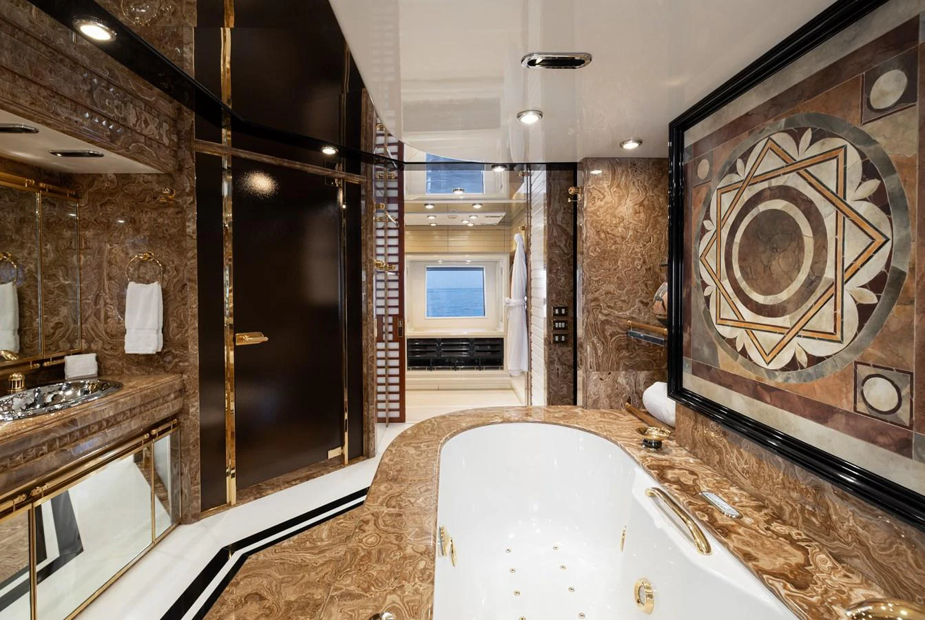 The luxurious bathroom features opulent marble surfaces and a large soaking tub with intricate wall art. aboard MY LADY Yacht for Sale