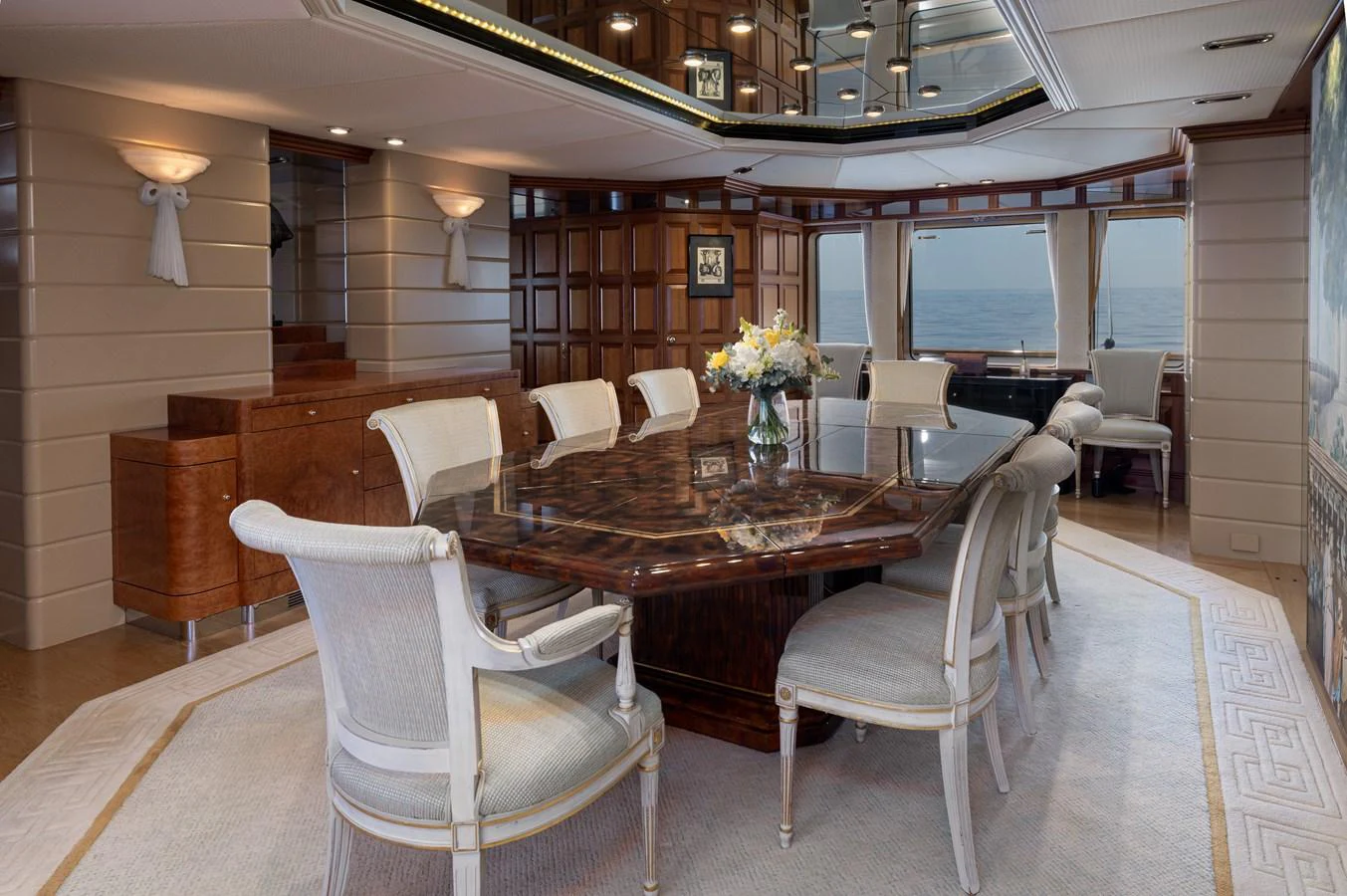 The yacht's dining area features an elegant table with plush seating and a view of the sea. aboard MY LADY Yacht for Sale