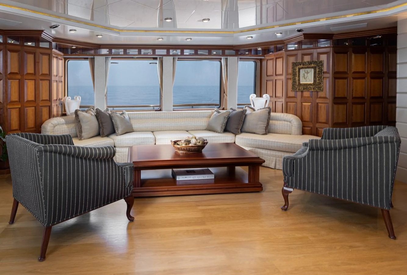 The salon features elegant wood paneling, plush seating, and large windows offering stunning ocean views. aboard MY LADY Yacht for Sale