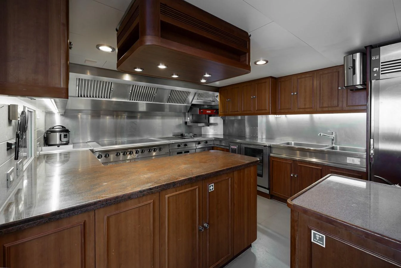 The yacht's galley features modern stainless steel appliances and ample wooden cabinetry for a sleek and functional cooking space. aboard MY LADY Yacht for Sale