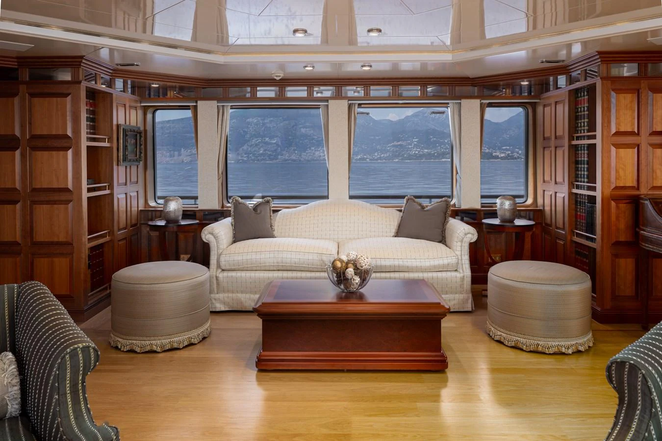 The yacht's salon features elegant wood paneling, plush seating, and large windows offering stunning sea views. aboard MY LADY Yacht for Sale