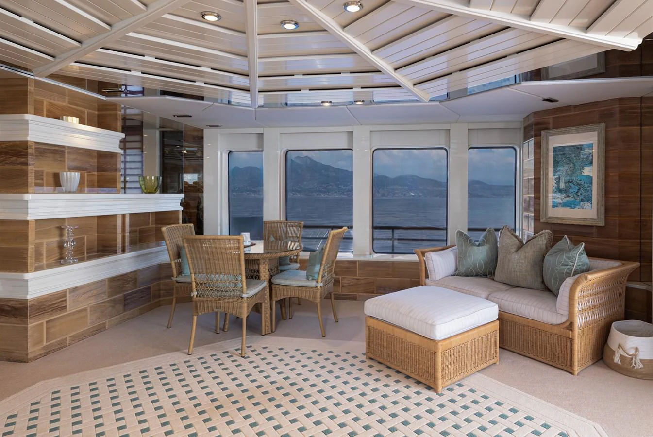 The salon features a cozy seating area with wicker furniture and panoramic windows offering stunning sea views. aboard MY LADY Yacht for Sale