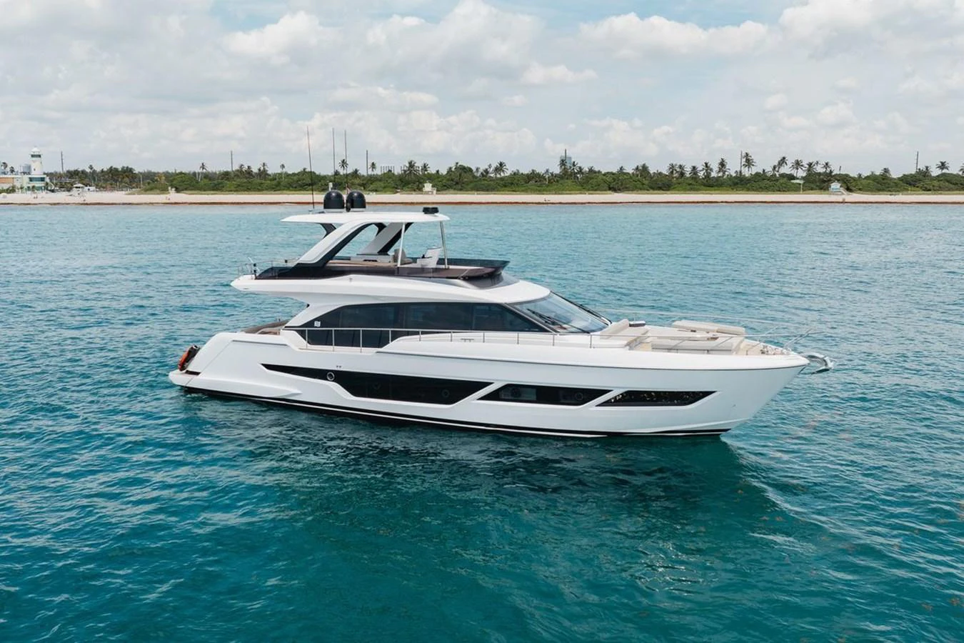 A sleek and modern yacht cruising on calm waters with a scenic shoreline in the background. aboard 2025 FERRETTI 670 KATRIN I Yacht for Sale