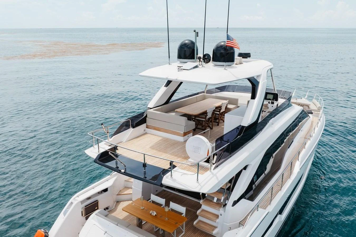 The yacht's aft deck features a spacious seating area and dining table, perfect for alfresco dining and relaxation. aboard 2025 FERRETTI 670 KATRIN I Yacht for Sale