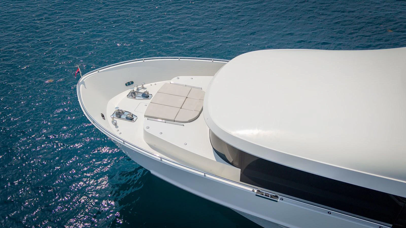 The yacht's sleek bow cuts through the pristine blue waters, showcasing its elegant design. aboard COOL CHANGE Yacht for Sale