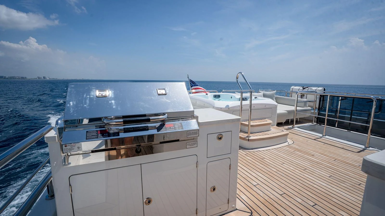 The sundeck features a sleek barbecue grill and ample space for relaxation with a stunning ocean view. aboard COOL CHANGE Yacht for Sale