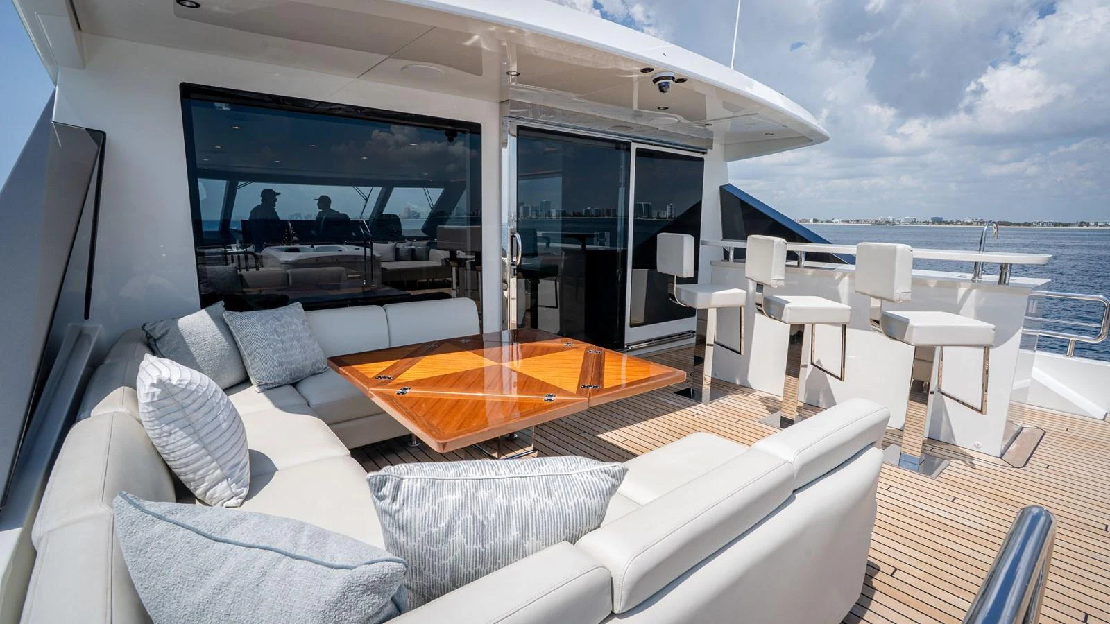 The aft deck features a luxurious seating area with a stylish table and bar stools, perfect for outdoor relaxation and entertainment. aboard COOL CHANGE Yacht for Sale