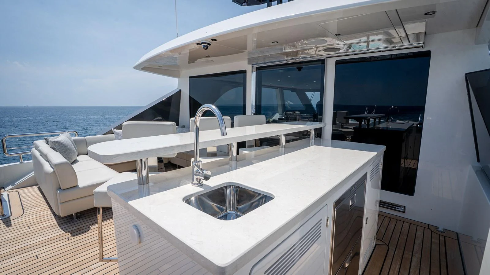 The flybridge features a sleek wet bar with a sink and ample seating, perfect for entertaining while enjoying ocean views. aboard COOL CHANGE Yacht for Sale