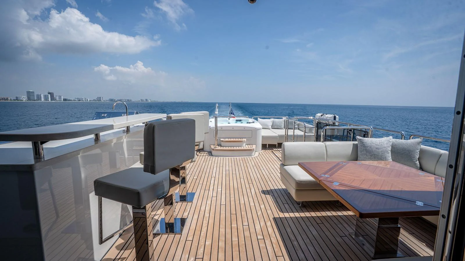 The aft deck offers a spacious and luxurious outdoor seating area with stunning ocean views. aboard COOL CHANGE Yacht for Sale