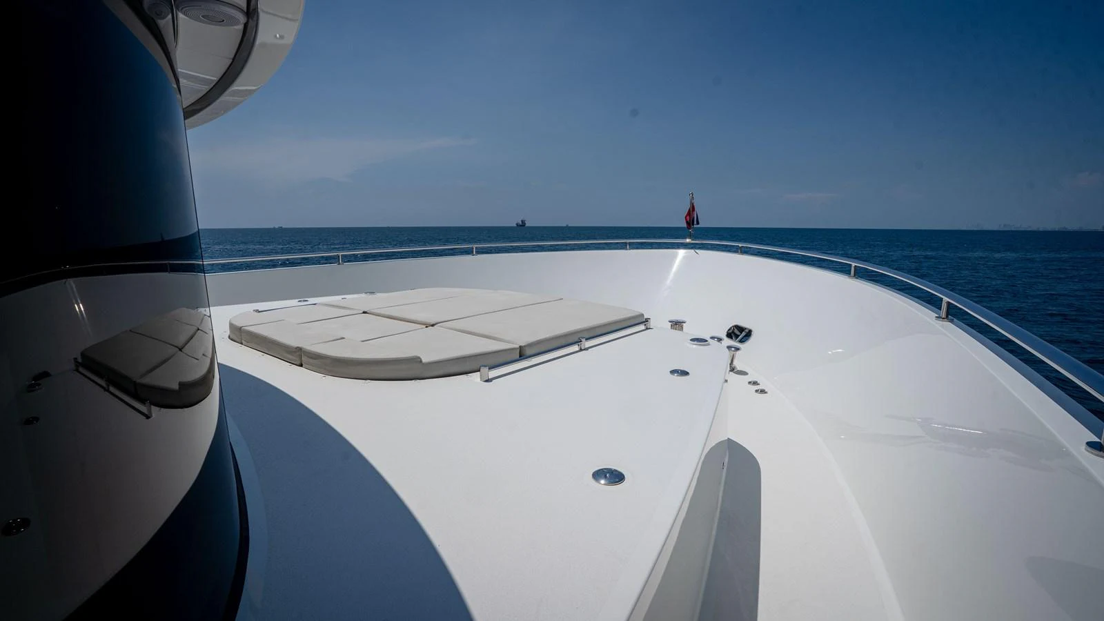 The yacht's foredeck features a spacious sunbathing area with plush cushions, set against a serene ocean backdrop. aboard COOL CHANGE Yacht for Sale