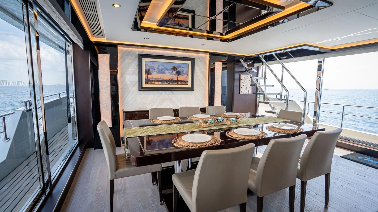 The yacht's dining area features a luxurious table set for a meal, with large windows offering stunning ocean views. aboard COOL CHANGE Yacht for Sale