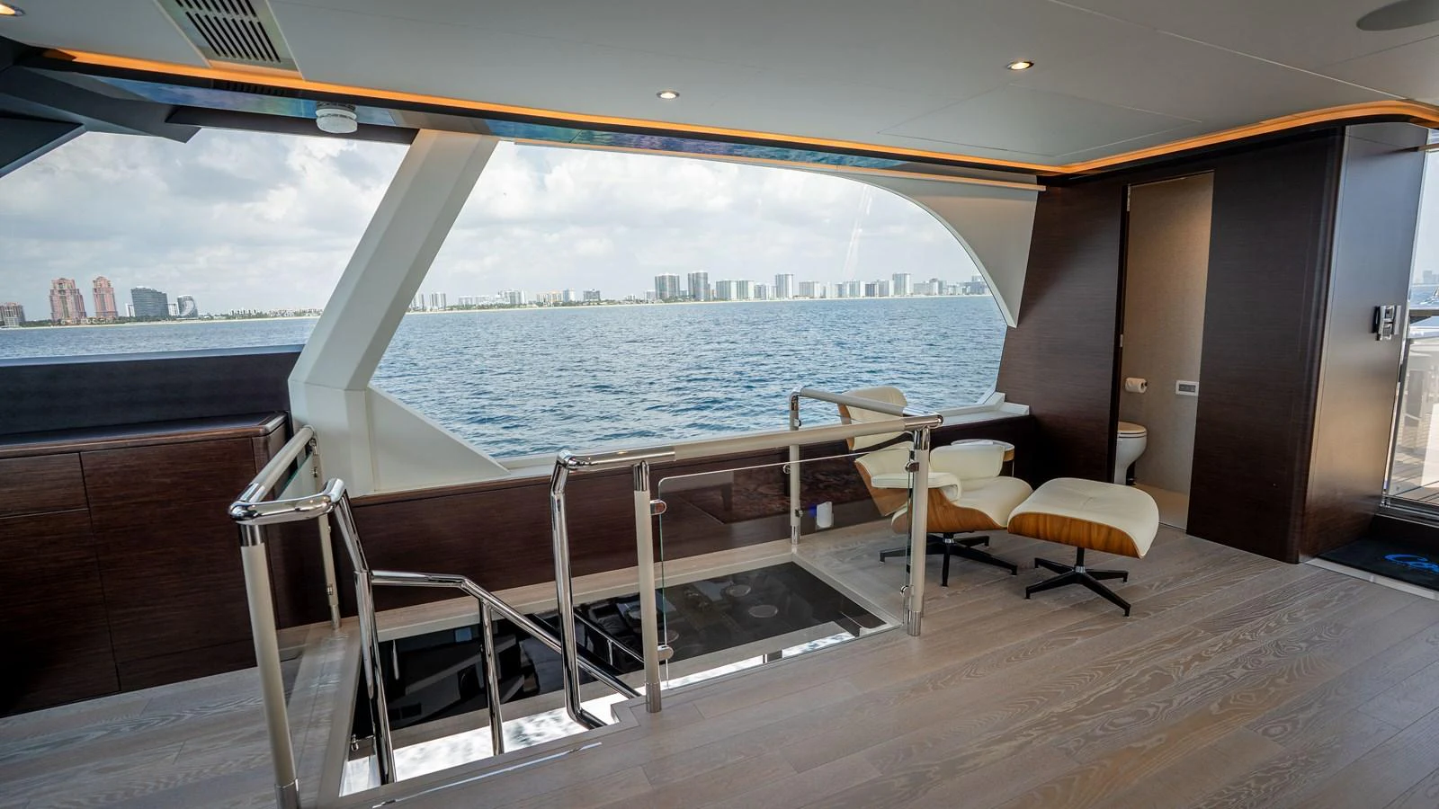 The upper deck lounge offers a serene view of the sea through large windows, complemented by modern furnishings. aboard COOL CHANGE Yacht for Sale