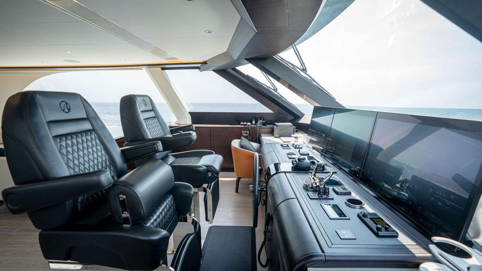 The helm station features luxurious seating and state-of-the-art navigation equipment with expansive windows offering a clear view of the sea. aboard COOL CHANGE Yacht for Sale