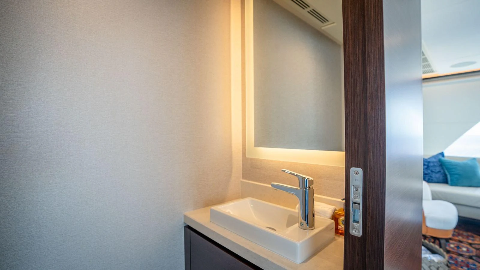 A modern bathroom with a sleek sink and illuminated mirror. aboard COOL CHANGE Yacht for Sale