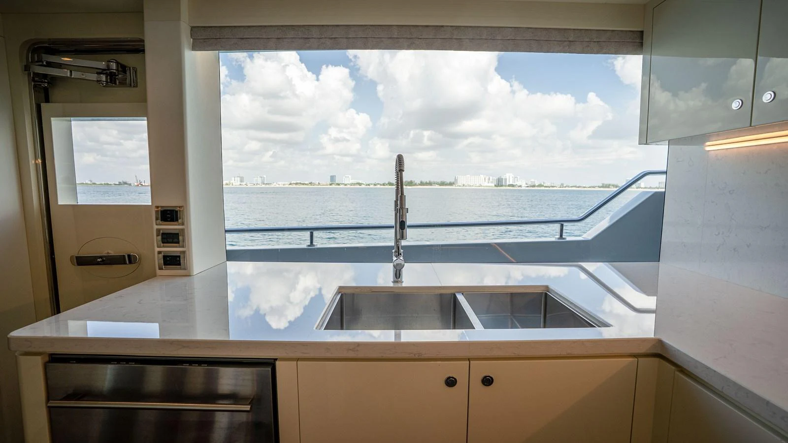 The galley features a sleek, modern design with a large window offering a stunning view of the water. aboard COOL CHANGE Yacht for Sale