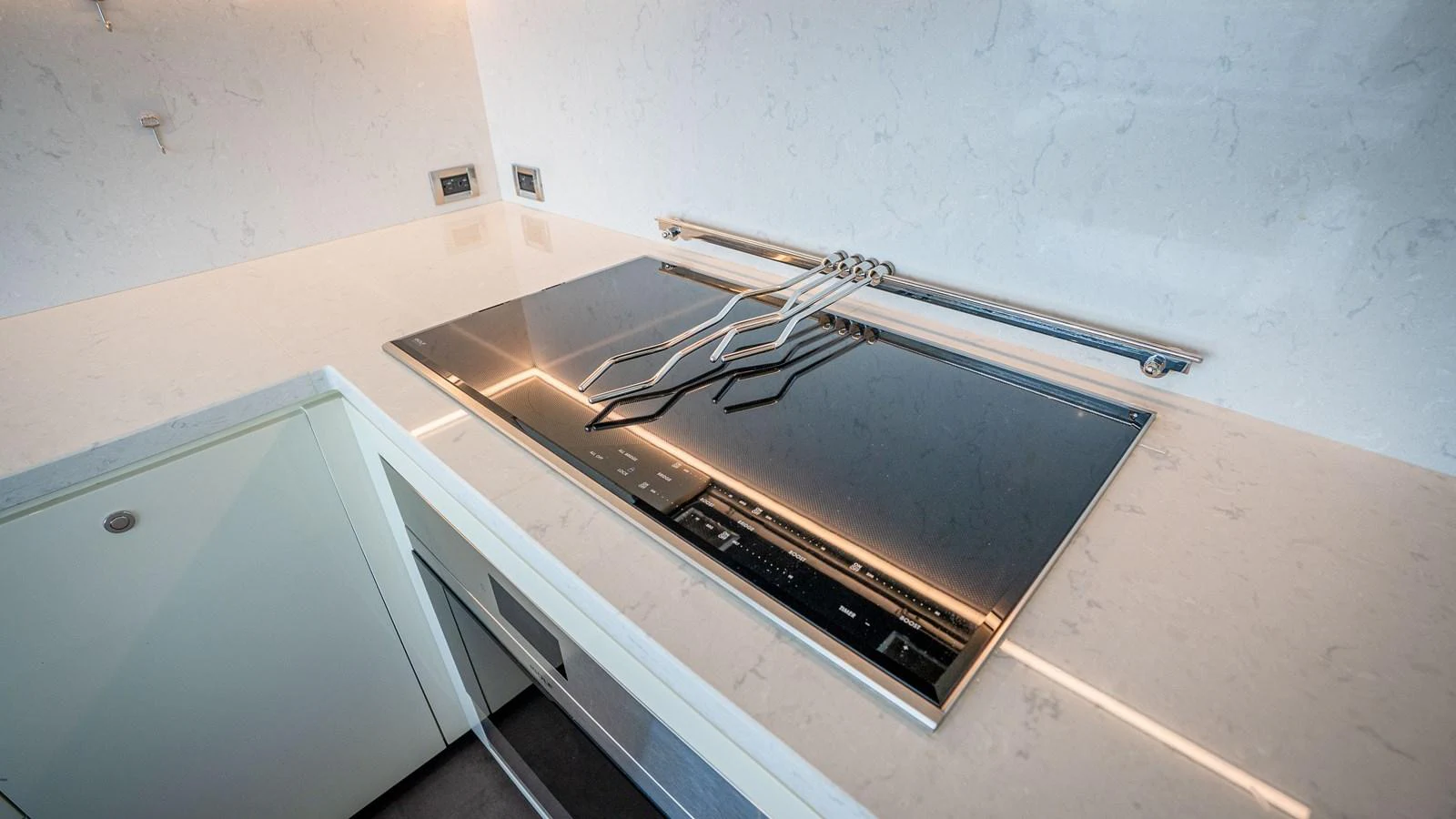 The yacht's galley features a sleek, modern stovetop with a minimalist design. aboard COOL CHANGE Yacht for Sale