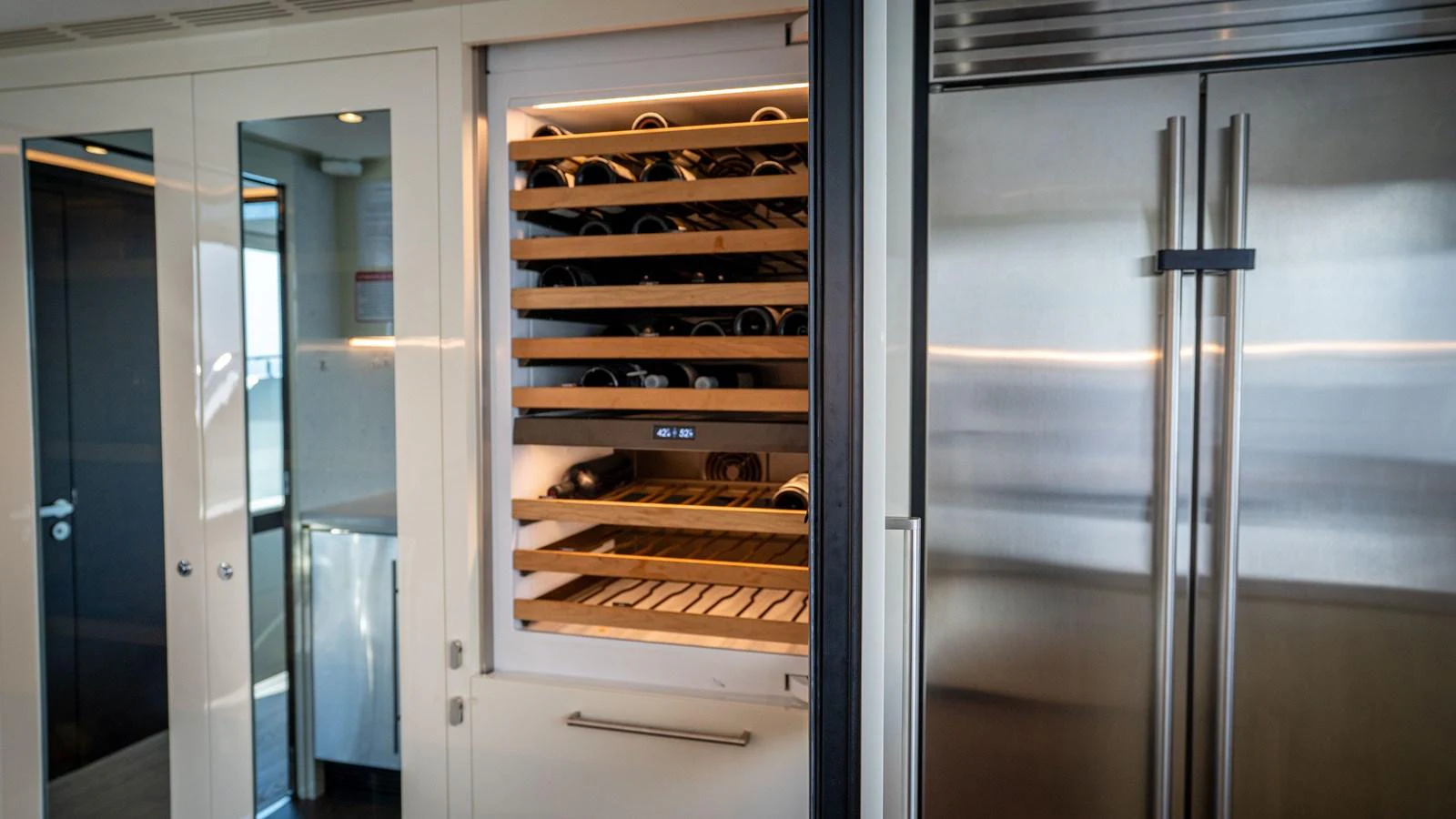 The yacht's galley features a sleek wine cooler and stainless steel refrigerator, perfect for gourmet meal preparation. aboard COOL CHANGE Yacht for Sale