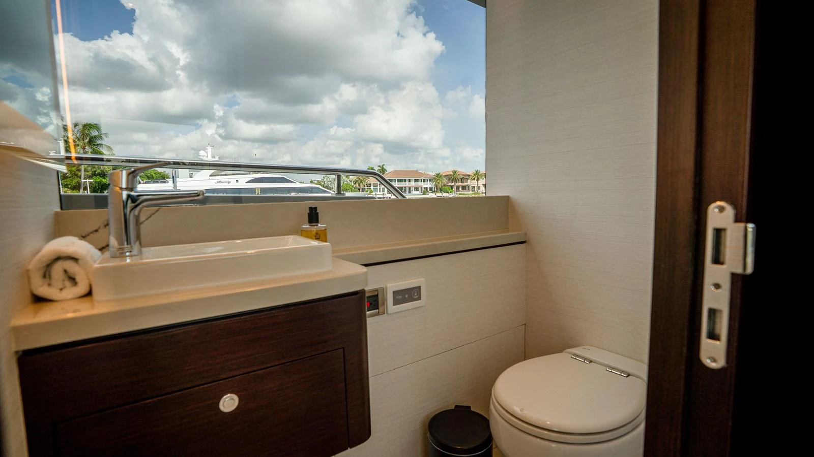 A modern yacht bathroom with a sleek sink and a view of the water through the window. aboard COOL CHANGE Yacht for Sale