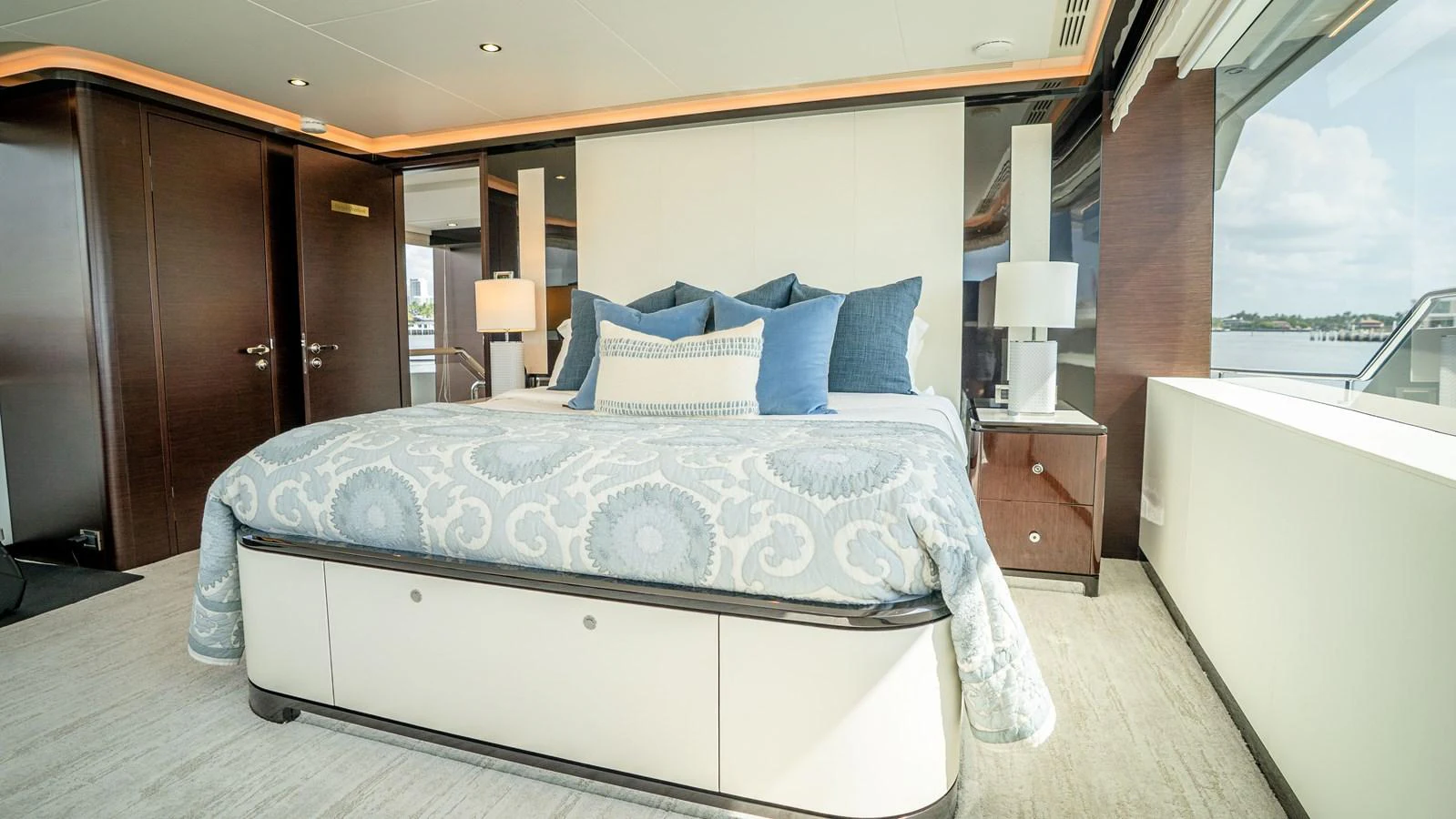 The stateroom features a luxurious bed with elegant bedding and ample natural light from large windows. aboard COOL CHANGE Yacht for Sale