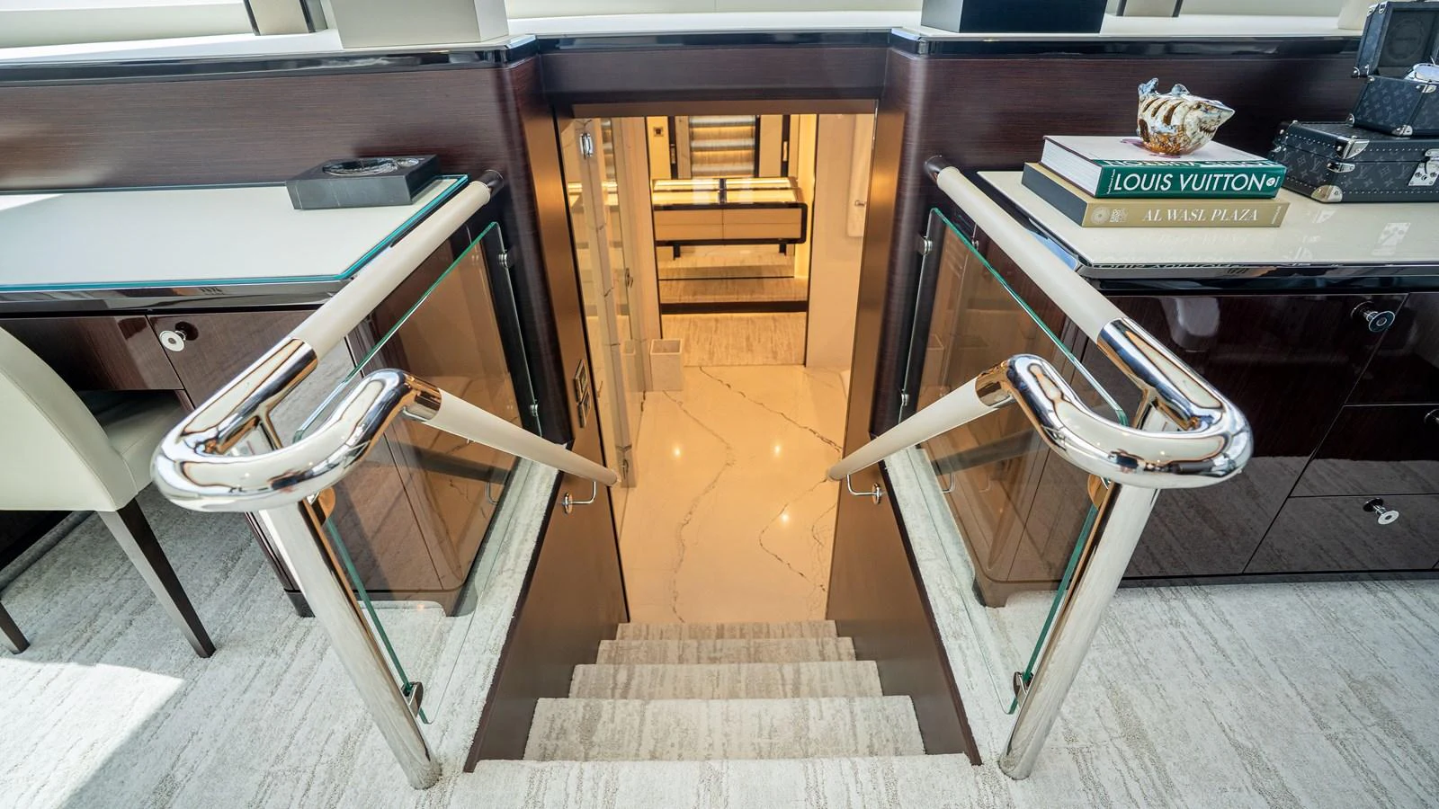 A luxurious staircase with polished handrails leads to the lower deck, showcasing elegant design and premium materials. aboard COOL CHANGE Yacht for Sale