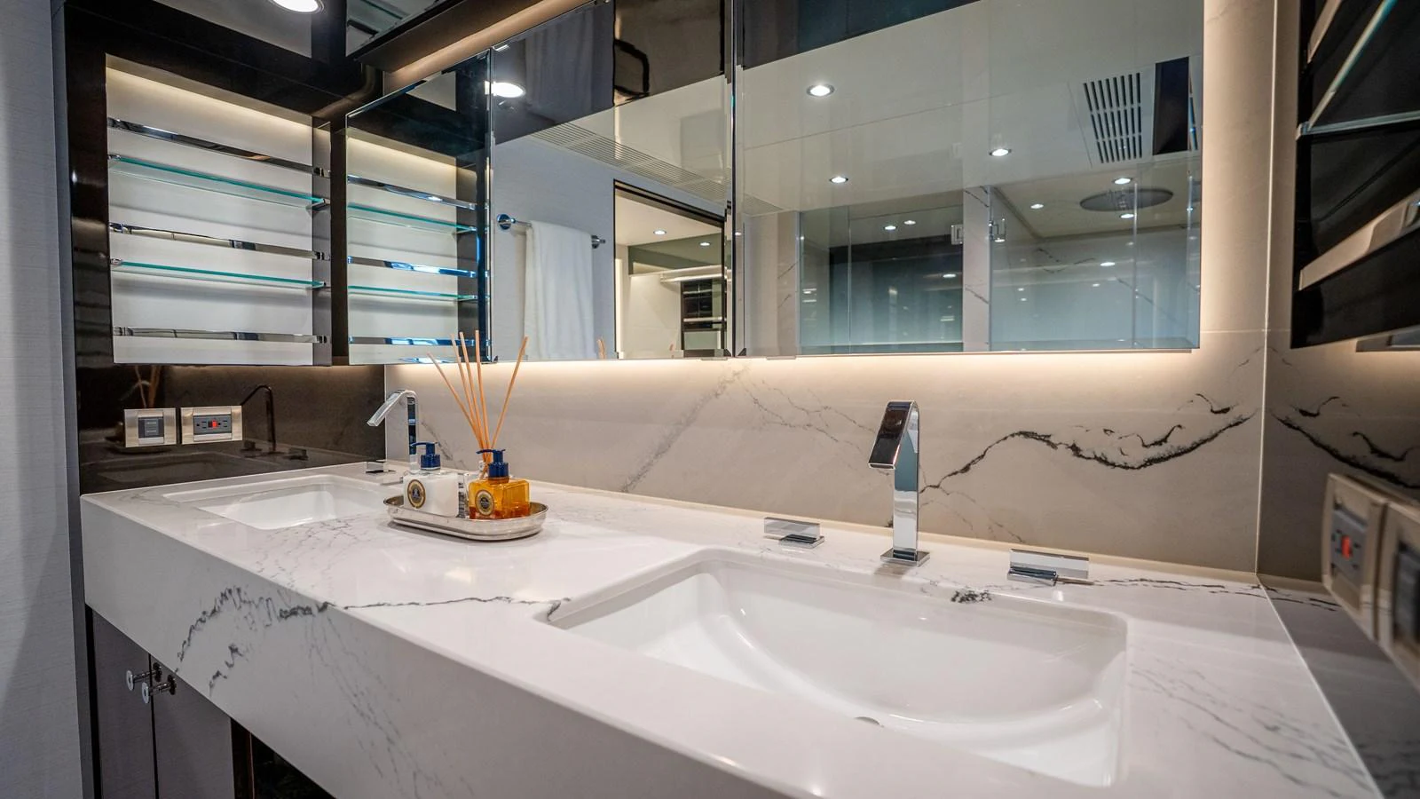 A luxurious yacht bathroom featuring a sleek double sink vanity with modern fixtures. aboard COOL CHANGE Yacht for Sale