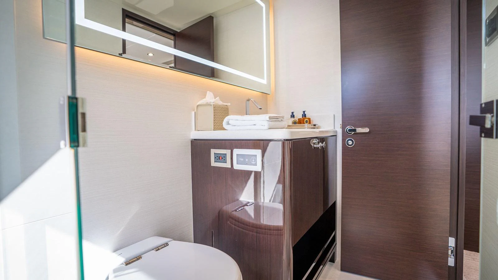 A modern yacht bathroom featuring sleek cabinetry and a well-lit mirror. aboard COOL CHANGE Yacht for Sale