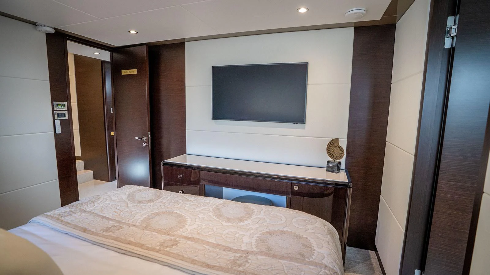 A luxurious stateroom featuring a large bed, a flat-screen TV, and elegant decor. aboard COOL CHANGE Yacht for Sale