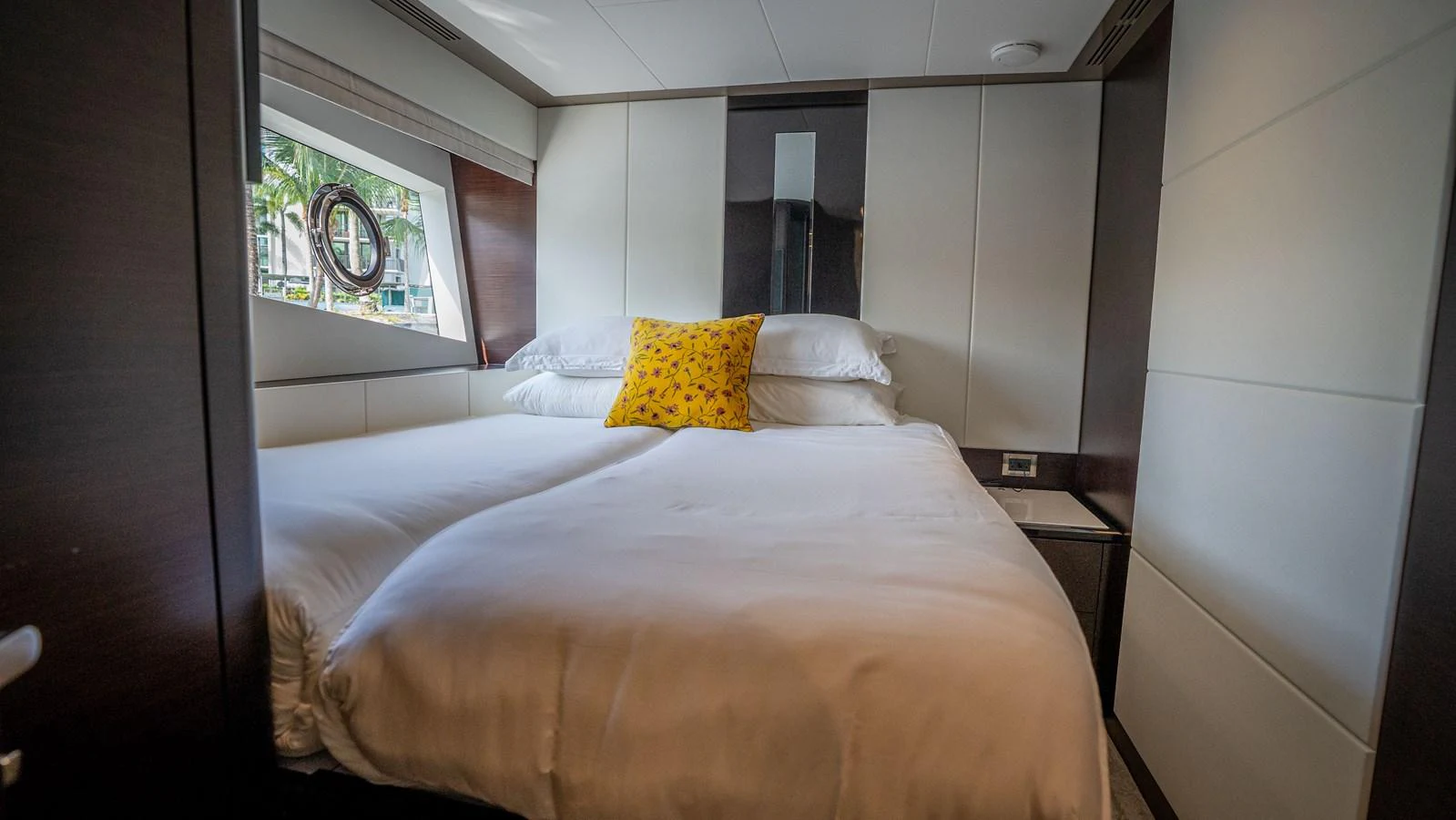 A cozy stateroom with a large bed and a bright yellow pillow. aboard COOL CHANGE Yacht for Sale