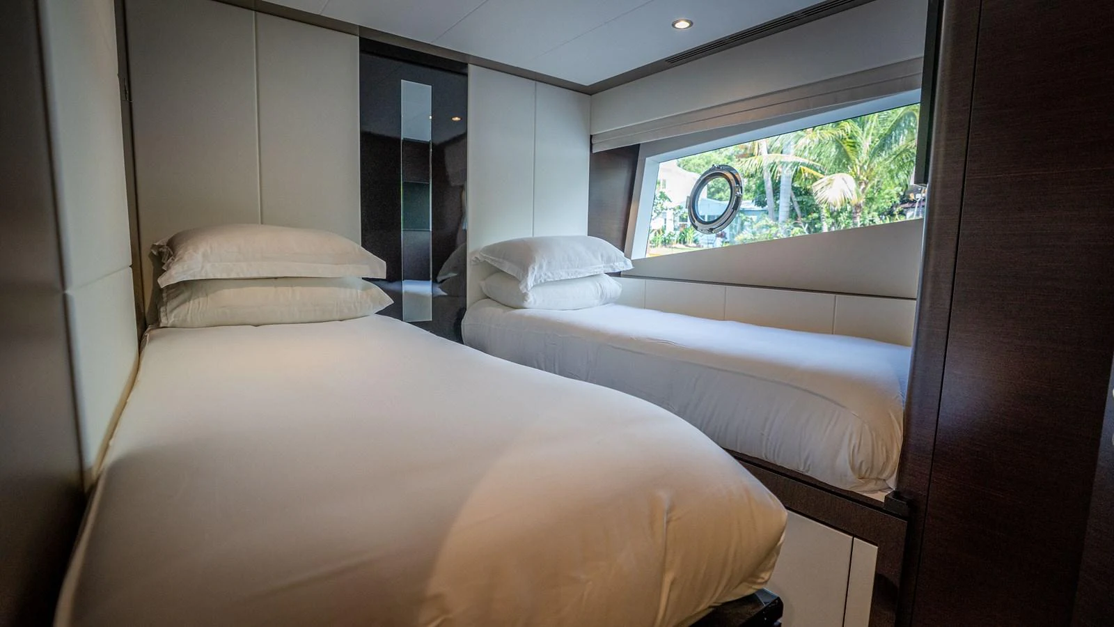The guest stateroom features twin beds and a large window offering a view of the surroundings. aboard COOL CHANGE Yacht for Sale